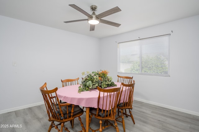 dining space with light wood-type flooring, ceiling fan, and baseboards