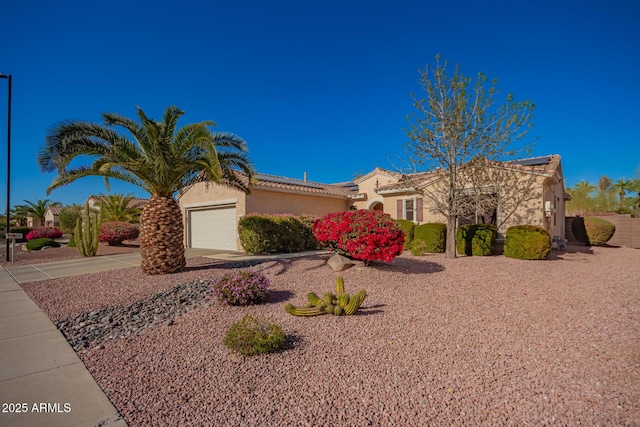 view of front of house featuring a tile roof, driveway, an attached garage, and stucco siding