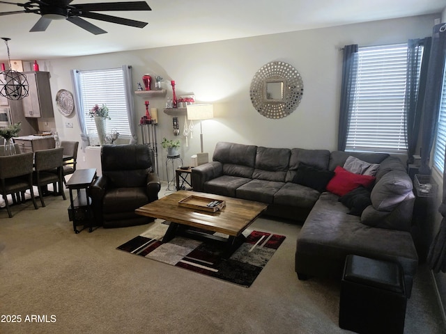 carpeted living room with ceiling fan