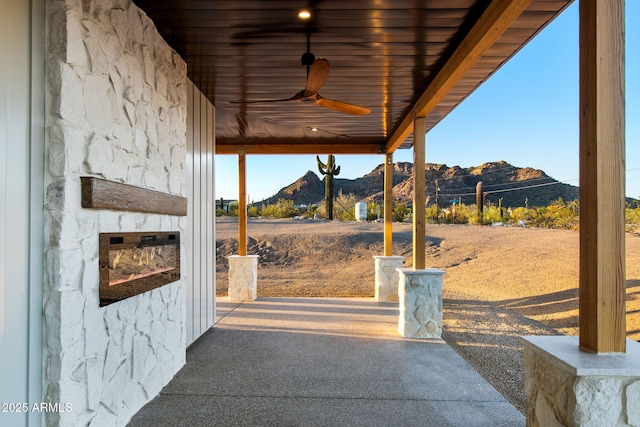 view of patio / terrace featuring a mountain view and a ceiling fan