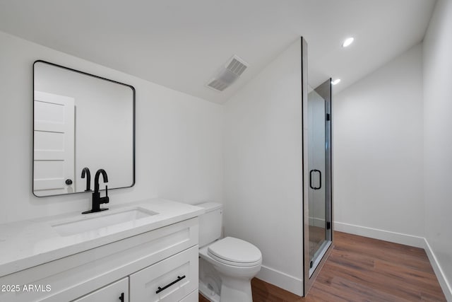 bathroom with vanity, toilet, visible vents, vaulted ceiling, and wood finished floors