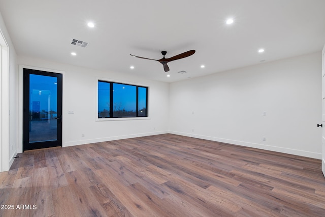 empty room with visible vents, wood finished floors, a ceiling fan, and recessed lighting