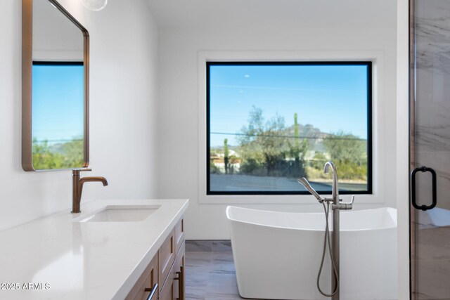 bathroom with a shower stall, a freestanding bath, marble finish floor, and vanity