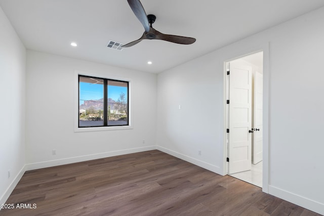 spare room with ceiling fan, visible vents, baseboards, recessed lighting, and wood finished floors