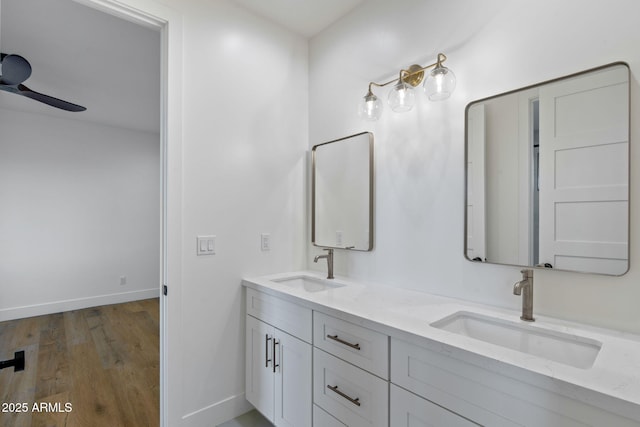 bathroom featuring wood finished floors, a ceiling fan, baseboards, and a sink