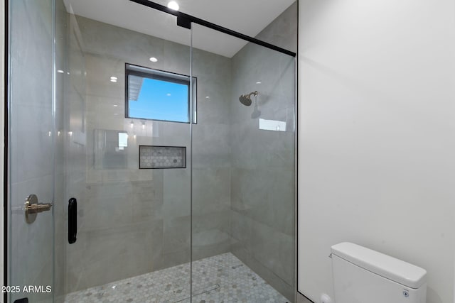 full bath featuring toilet and a stall shower