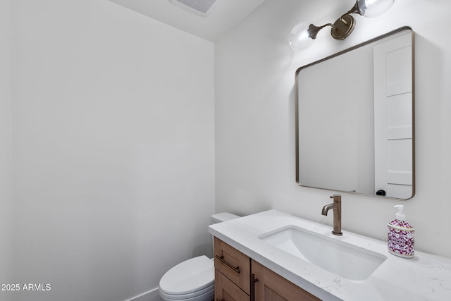 half bath featuring visible vents, toilet, and vanity