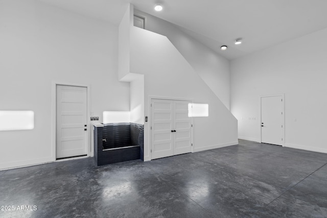 bonus room featuring baseboards and concrete floors