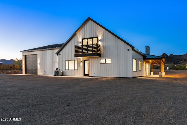 modern inspired farmhouse with a garage, a standing seam roof, board and batten siding, and metal roof