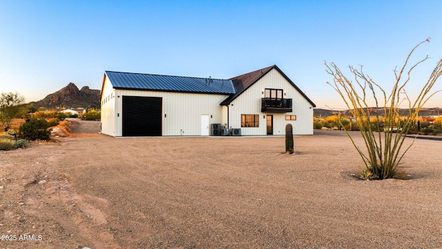 modern farmhouse style home with metal roof, an outdoor structure, a pole building, a detached garage, and a mountain view