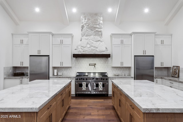 kitchen with premium appliances, beam ceiling, and a large island