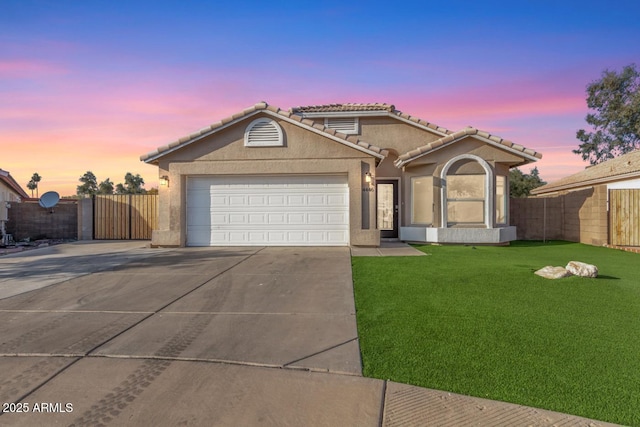 view of front of home featuring a garage and a yard