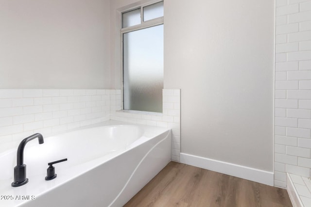 bathroom with wood-type flooring and a bathtub