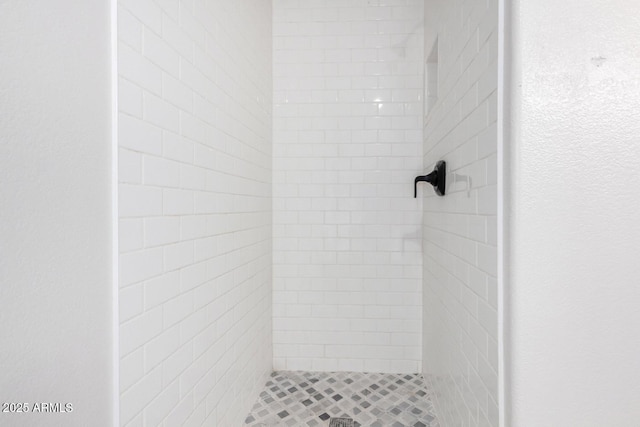 interior details featuring tiled shower