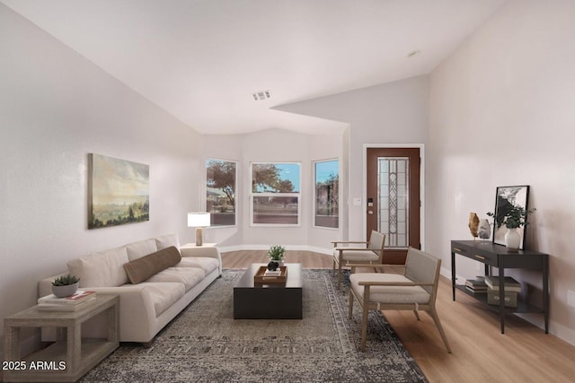 living room with light hardwood / wood-style floors and vaulted ceiling