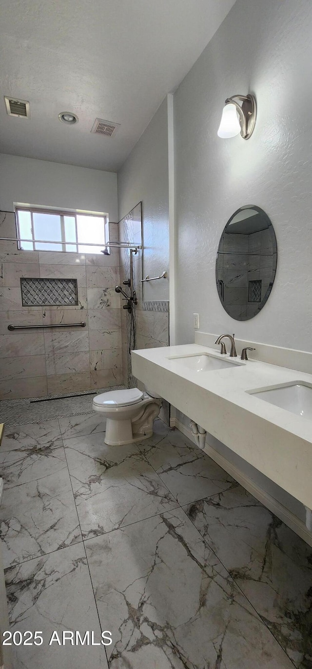 bathroom featuring toilet, marble finish floor, visible vents, and walk in shower