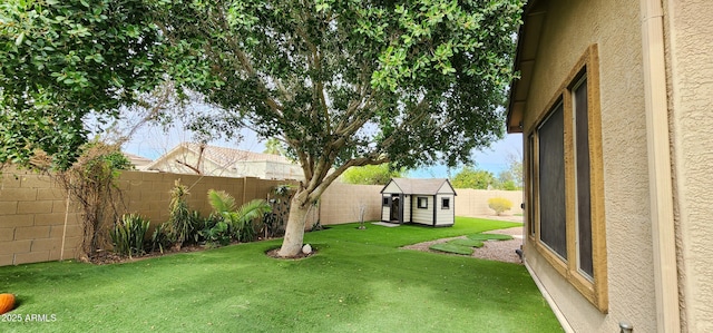 view of yard featuring a storage shed, an outdoor structure, and a fenced backyard