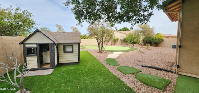 view of yard featuring an outbuilding, a shed, and a fenced backyard