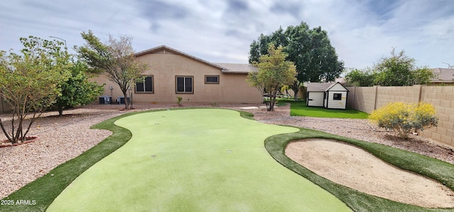 exterior space with an outbuilding, stucco siding, a storage shed, central AC unit, and a fenced backyard