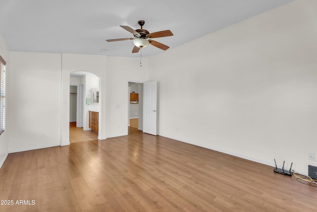 30215 N Joshua Tree Dr, Florence, AZ 85132 - empty room featuring arched walkways, ceiling fan, and light wood-style floors