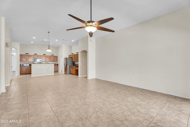 30215 N Joshua Tree Dr, Florence, AZ 85132 - unfurnished living room featuring arched walkways, vaulted ceiling, a ceiling fan, recessed lighting, and light tile patterned floors