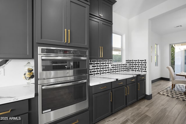 kitchen with plenty of natural light, visible vents, tasteful backsplash, and stainless steel double oven