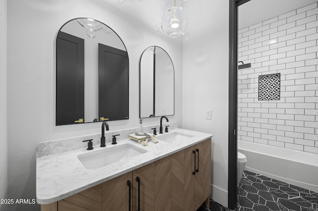 bathroom featuring tile patterned flooring, double vanity, toilet, and a sink