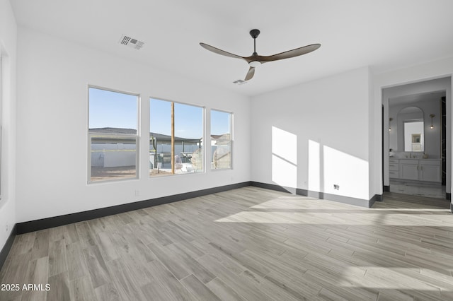 unfurnished room featuring visible vents, baseboards, ceiling fan, and light wood finished floors