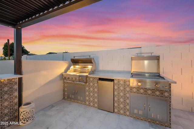 view of patio / terrace with a grill, an outdoor kitchen, and fence