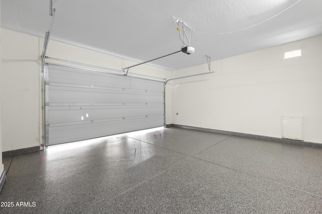 garage featuring a garage door opener and baseboards