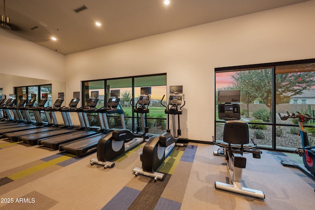 gym with visible vents, baseboards, carpet floors, recessed lighting, and a high ceiling