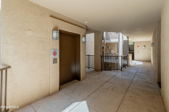 hallway featuring elevator and a textured wall