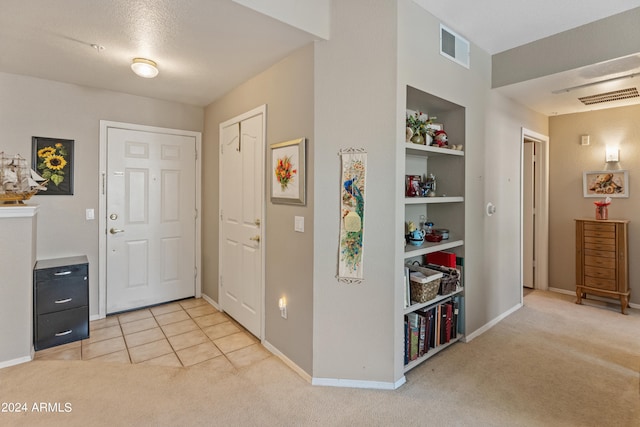 entrance foyer with light colored carpet and a textured ceiling