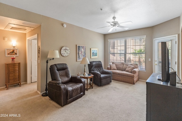 living room with ceiling fan, light colored carpet, and a textured ceiling