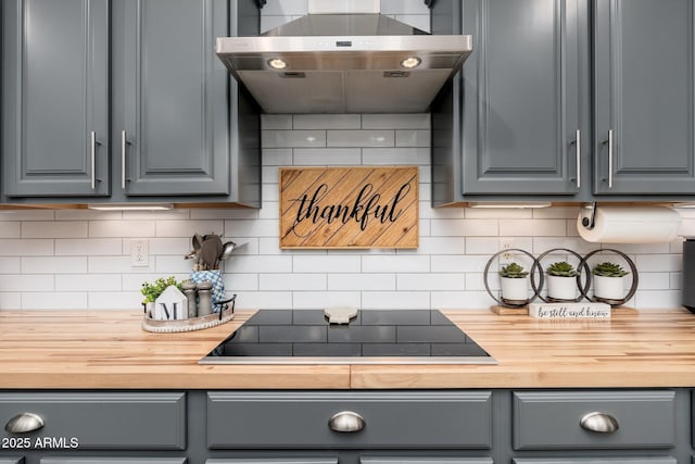 kitchen featuring wood counters, black electric stovetop, exhaust hood, and gray cabinets