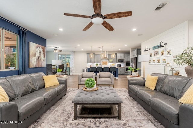 living room featuring recessed lighting, visible vents, light wood-style flooring, and ceiling fan