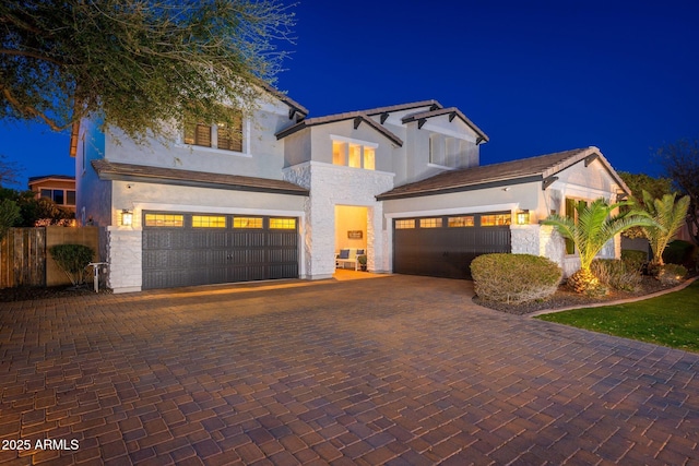 view of front facade featuring decorative driveway, a garage, and stucco siding