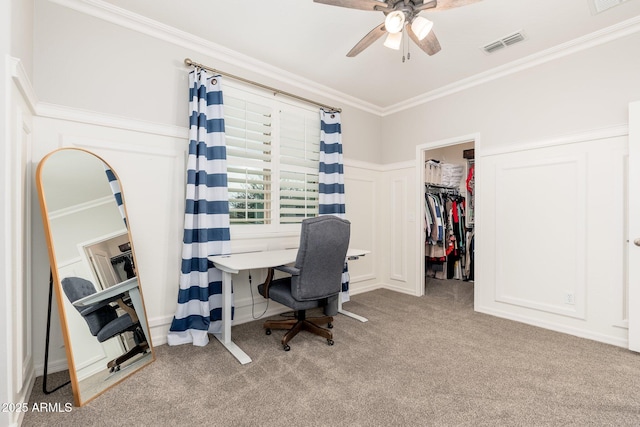 office space featuring carpet flooring, a ceiling fan, visible vents, and ornamental molding