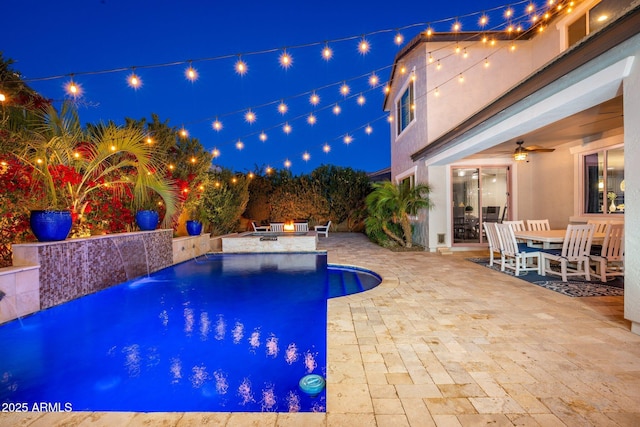 pool at twilight featuring a patio, area for grilling, a ceiling fan, and an outdoor pool