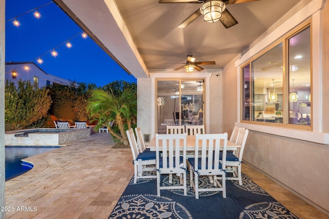 patio at twilight featuring an in ground hot tub, a ceiling fan, and an outdoor pool