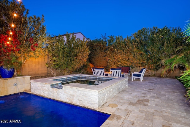 pool with an in ground hot tub, a fenced backyard, and a patio area