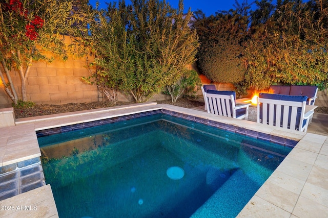 view of swimming pool featuring a fire pit and a fenced backyard