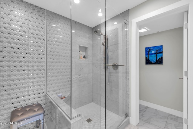 full bath with marble finish floor, a shower stall, and baseboards