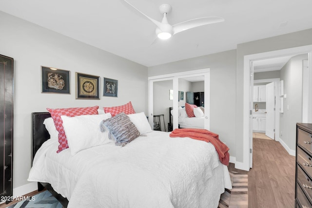 bedroom with ceiling fan, baseboards, and wood finished floors