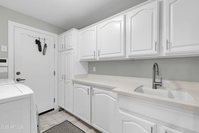 laundry room featuring cabinet space, marble finish floor, a sink, and washing machine and clothes dryer