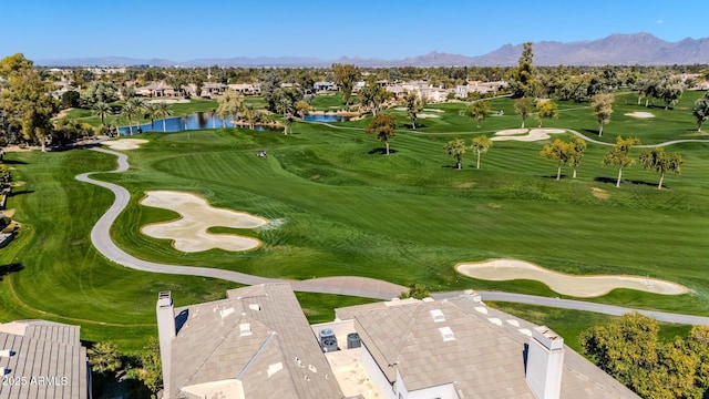 drone / aerial view with golf course view and a water and mountain view