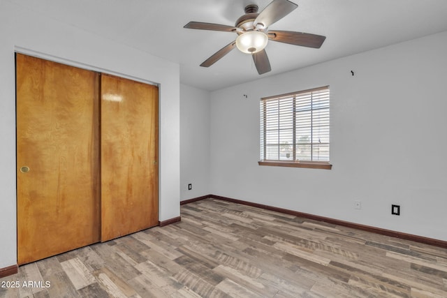 15210 S Country Club Way, Arizona City, AZ 85123 - unfurnished bedroom featuring light wood-type flooring, baseboards, a closet, and ceiling fan