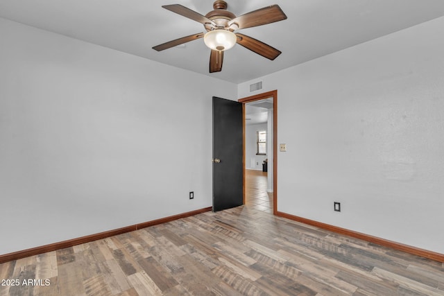15210 S Country Club Way, Arizona City, AZ 85123 - empty room with visible vents, baseboards, wood finished floors, and a ceiling fan
