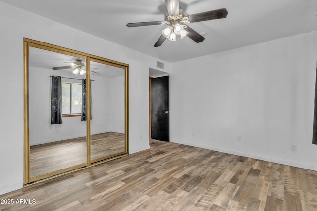 15210 S Country Club Way, Arizona City, AZ 85123 - unfurnished bedroom with ceiling fan, visible vents, baseboards, and wood finished floors