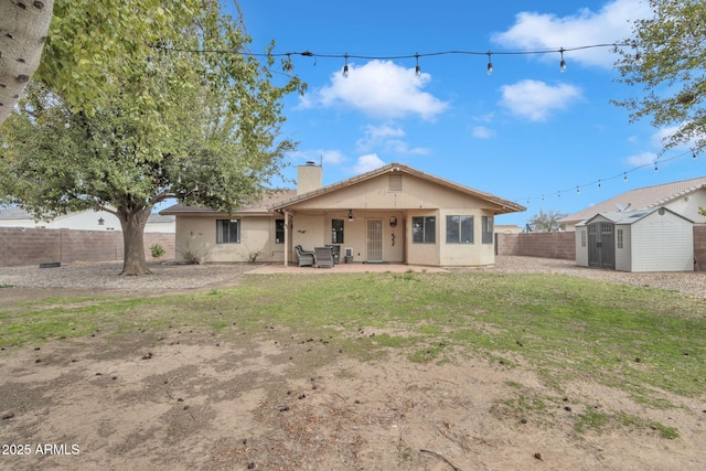 15210 S Country Club Way, Arizona City, AZ 85123 - view of front facade with a chimney, a fenced backyard, an outdoor structure, a storage unit, and a patio